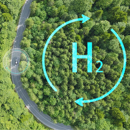 Hydrogen symbol in forest from above with road