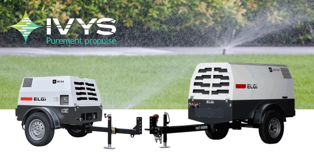 Compresseurs d’air portatifs ELGi avec marquage IVYS « Purement propulsé », positionnés sur une pelouse avec arroseurs en arrière-plan. Équipement mobile pour purge d’irrigation, hivernisation de systèmes extérieurs, compresseurs professionnels pour applications commerciales.