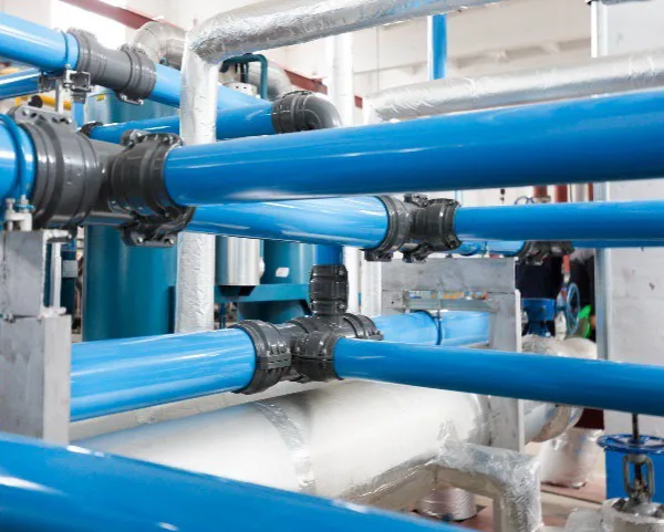 Blue aluminum compressed air pipes connected with modular fittings in an industrial installation.