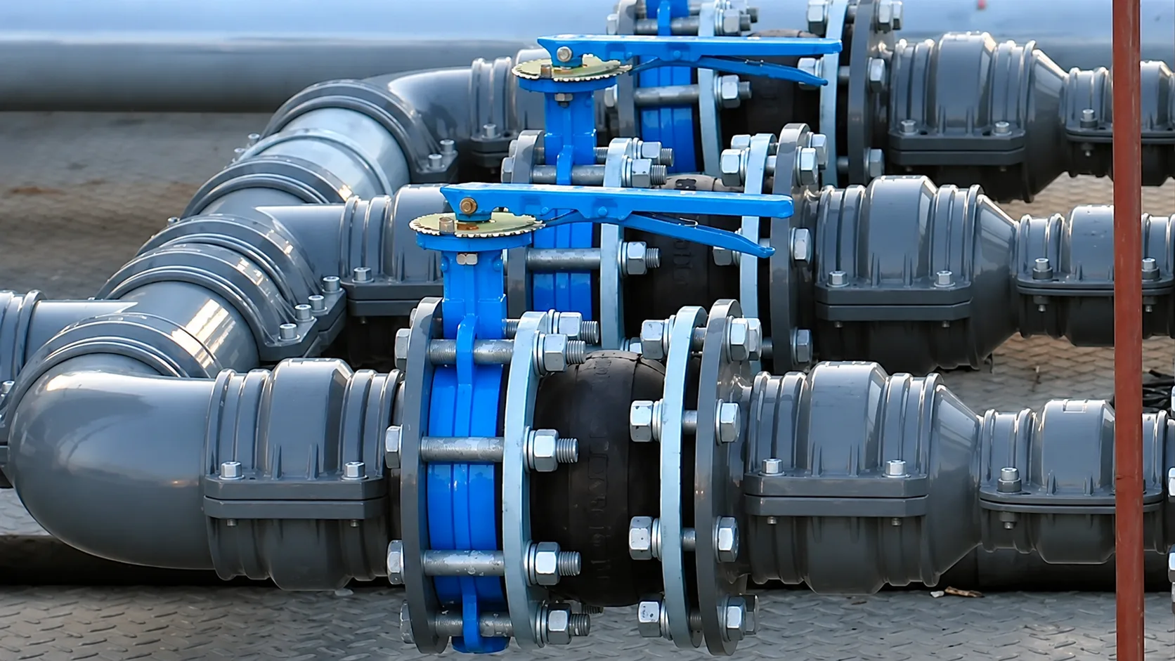 Industrial piping system featuring large-diameter blue aluminum pipes, isolation valves, expansion joints, and modular fittings designed for reliable compressed air distribution.